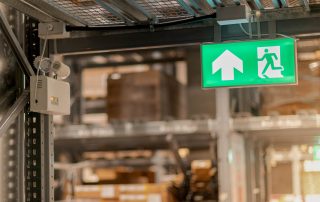 Emergency fire exit sign show the way to escape at the public area, warehouse store, For the security first about the being fire concept.
