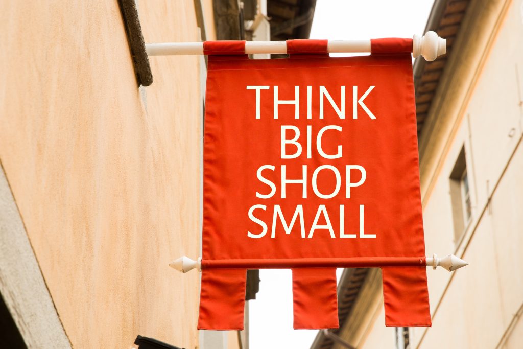 banner hanging from a pole with the text "think big shop small" written on it