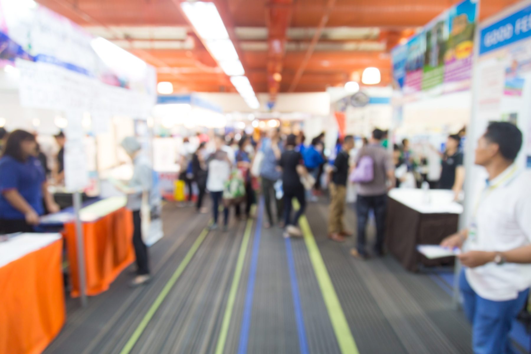 Abstract blurred trade show with people for background.